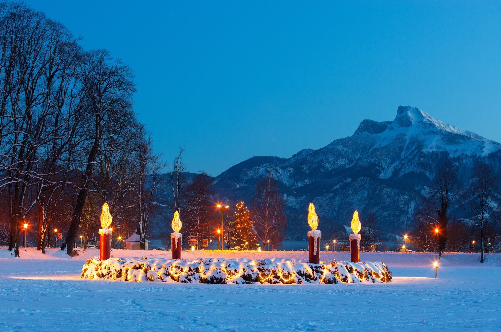 Ein großer leuchtender Adventkranz im Schnee im Mondsee.